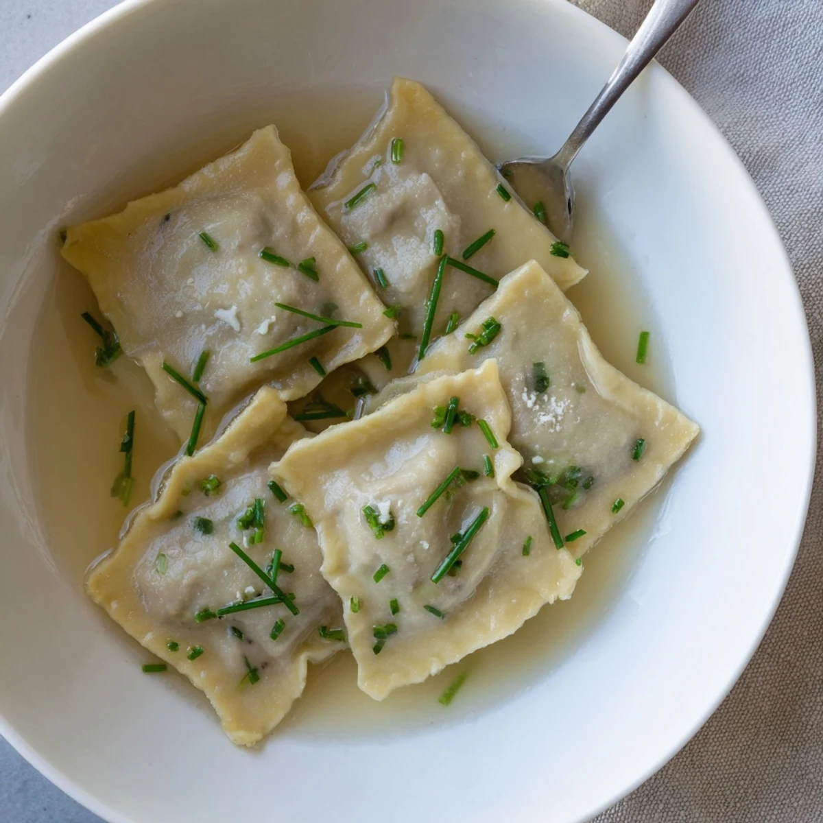 Zarte Swabische Maultaschen in Brühe mit würzigem Fleisch und frischem Spinat.